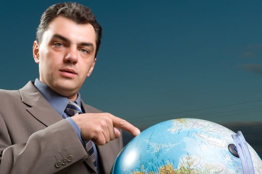 man in a suit against the evening sky with globe