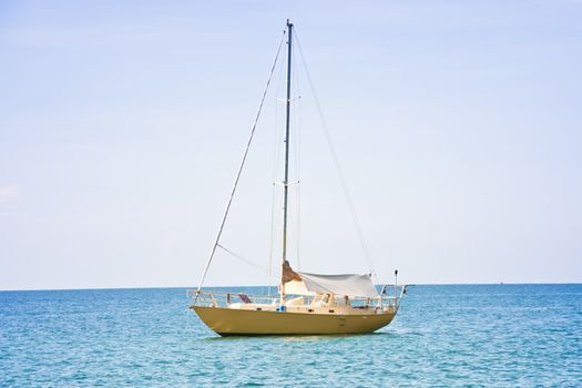 Sailboat in the sea, near the fishing boats of the villagers.