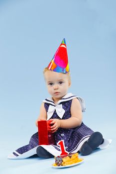 A little sweet girl with a cake and a candle in her first birthday.