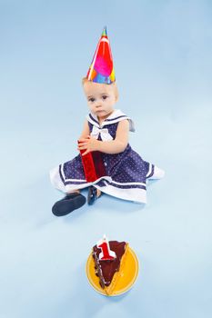 A little sweet girl with a cake and a candle in her first birthday.