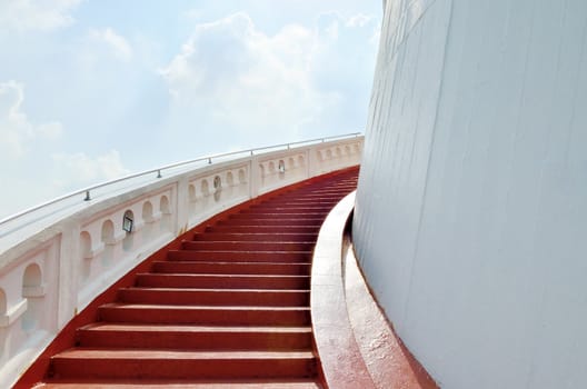 Red stair to the Buddhist temple on hill with cloud background