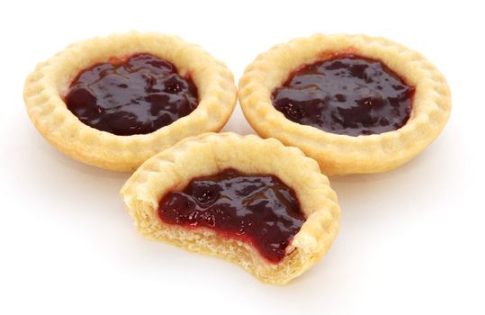 Three jam tarts, one with a bite taken, isolated on a white background