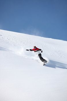 Man snowboarding down hill