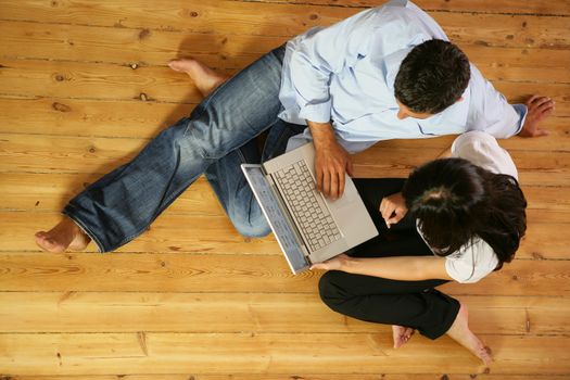 Couple in living-room with laptop computer, top-view