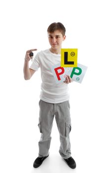 Full length teenager.  He is holding a car key and various licence plate signs for learner drivers.  White background.