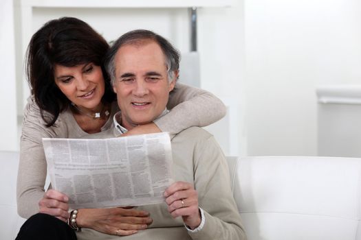Mature couple reading a newspaper