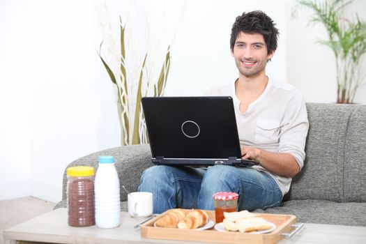 man doing computer at breakfast