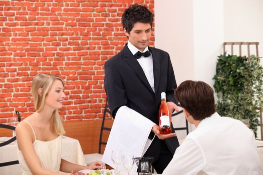 Young couple choosing rose wine in a restaurant