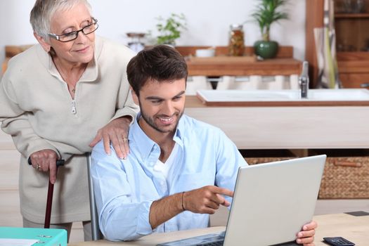 Man showing old lady how to use computer