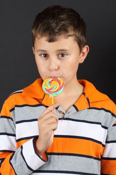 Boy eating lollipop close up