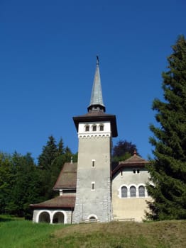 Facade and belltower of a small church surrounded by trees and nature by beautiful weather