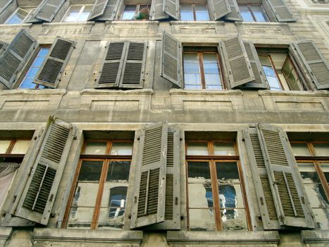 Facade of an old and dirty building with its broken windows