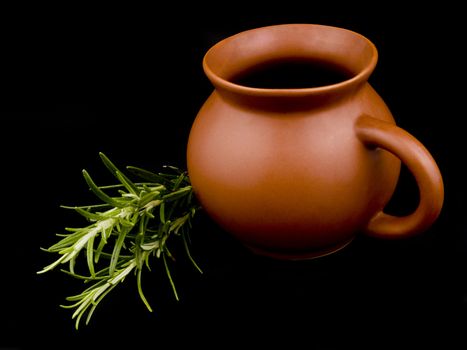 Ceramic cup and fresh rosemary on black background
