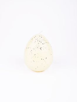 White candle formed in egg on white background