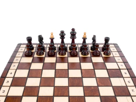 Black chess-men on wooden chessboard on white background