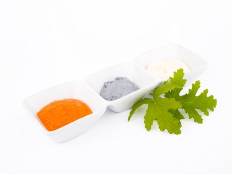 Orange peeling, grey mask and white cream in porcelain bowls on white background.