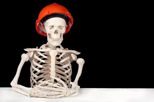 A skeleton with hard hat symbolizes death to the building industry.