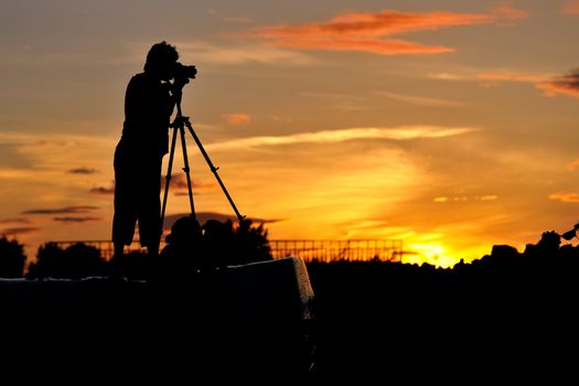 Silhouette of a photographer shooting sunset scene