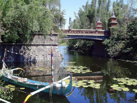 A boat a bridge and a river.