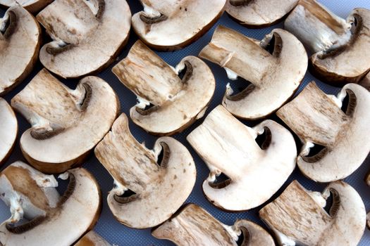 A group of sliced mushrooms laid out on a chopping board
