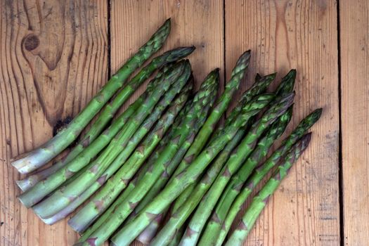 Group of freshly harvested asparagus on a garden bench