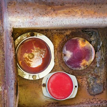 Rusty taillight on back of old truck.