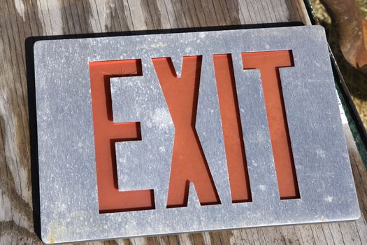 Old exit sign lying on wood.