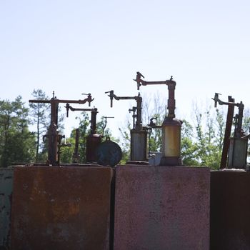 Old rusted metal machinery silhouetted against sky.