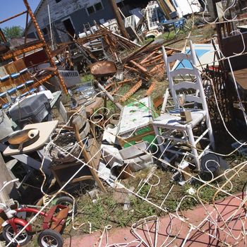 Chaotic mess of junk strewn across junkyard outdoors.