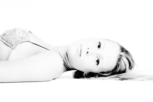 High key studio portrait of a young blond girl in bra only