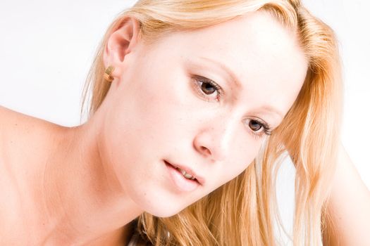 Studio portrait of a young blond girl in a thinking pose