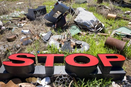 Word "STOP" lying amongst junk and garbage.