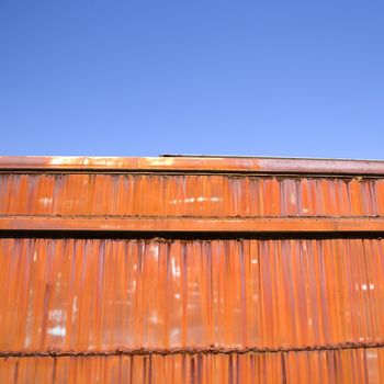 Metal orange siding and blue sky.
