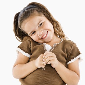 Cute little hispanic girl standing smiling at viewer.