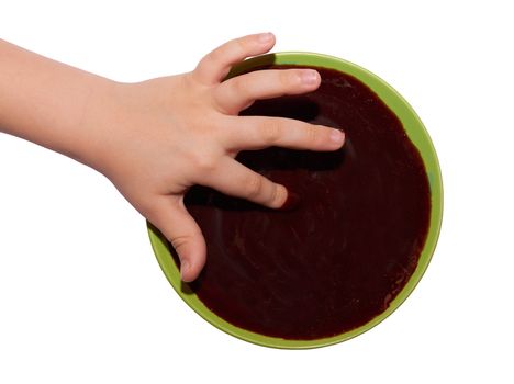 A small child's hand in a bowl of chocolate isolated on white background