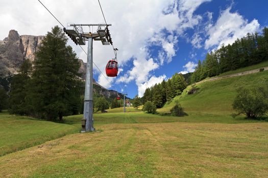 cablaway over meadow and wood in Badia valley, Italian Dolomites