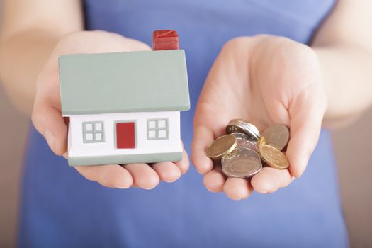 Little house toy and money in woman's hands