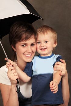  Mother with the child under a umbrella in studio