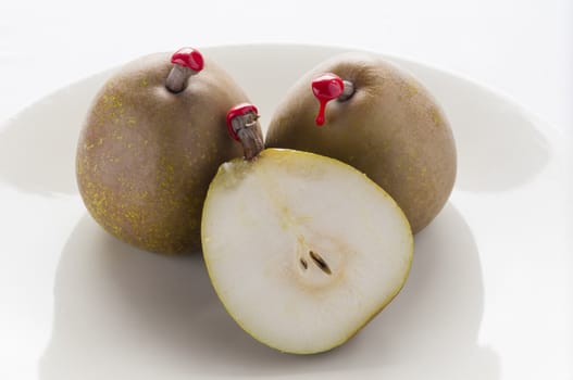 Green pears with red sealing wax on stalk