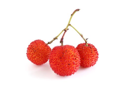 three ripe arbutus fruits over white background
