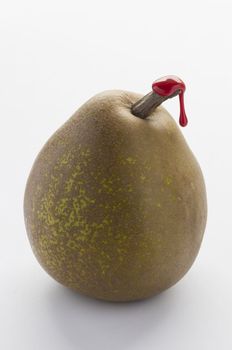 Green pear with red sealing wax on stalk