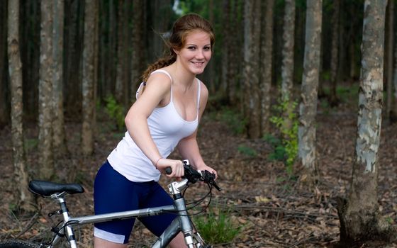Active girl woman in forest with mountain bike