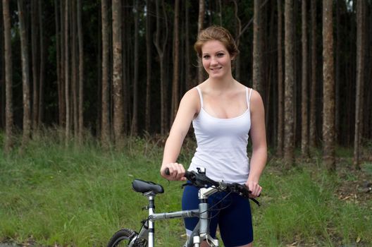 Active girl woman in forest with mountain bike