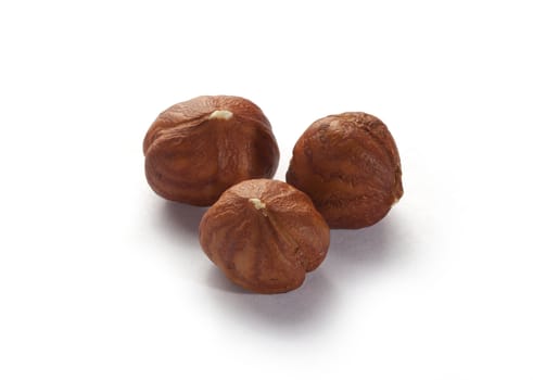 Three isolated brown huzelnuts on the white background