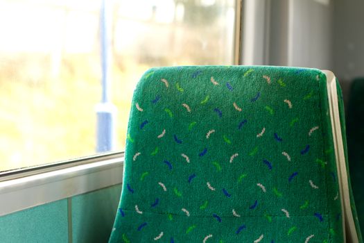 empty seat by the window on a train carrige

