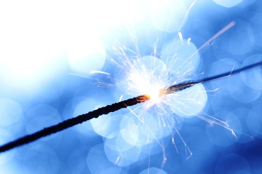 sparkler on blue bokeh background macro close up