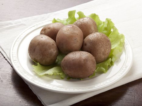 Potato boiled with their jackets and lettuce on the plate