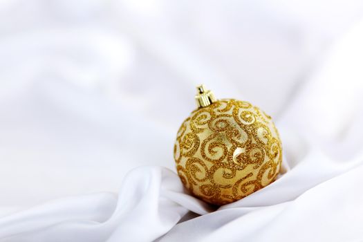  gold christmas ball on white silk