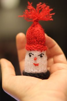 Hand holding a hand crafted santa figure.