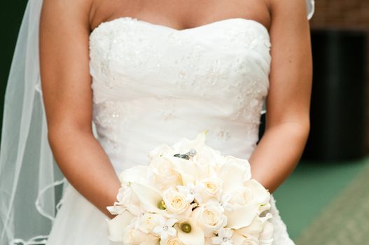 Up close shot of bride holding bouquet of flowers with wedding rings.